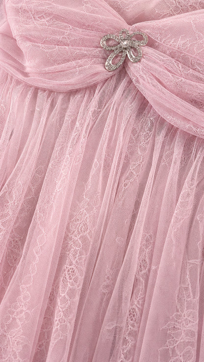Close-up of pink tulle fabric and crystal bow brooch detail