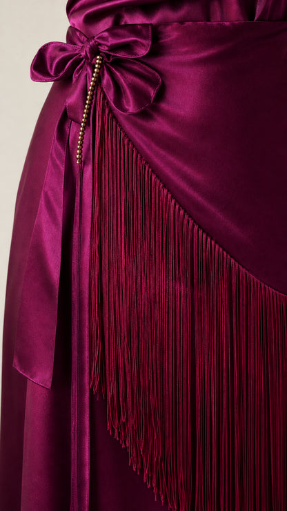 Close up of fringe detailing and waist tie on magenta dress