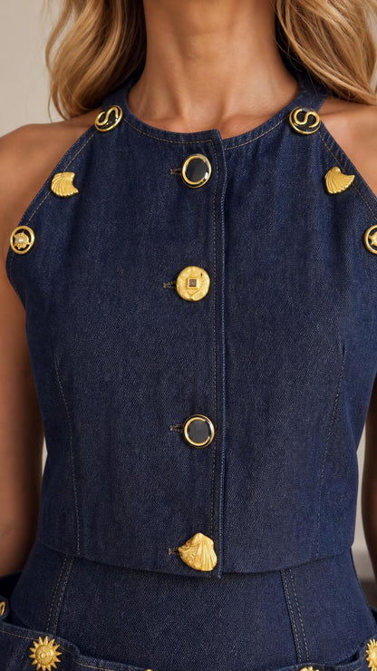 Close-up of gold-toned decorative buttons on blue denim top