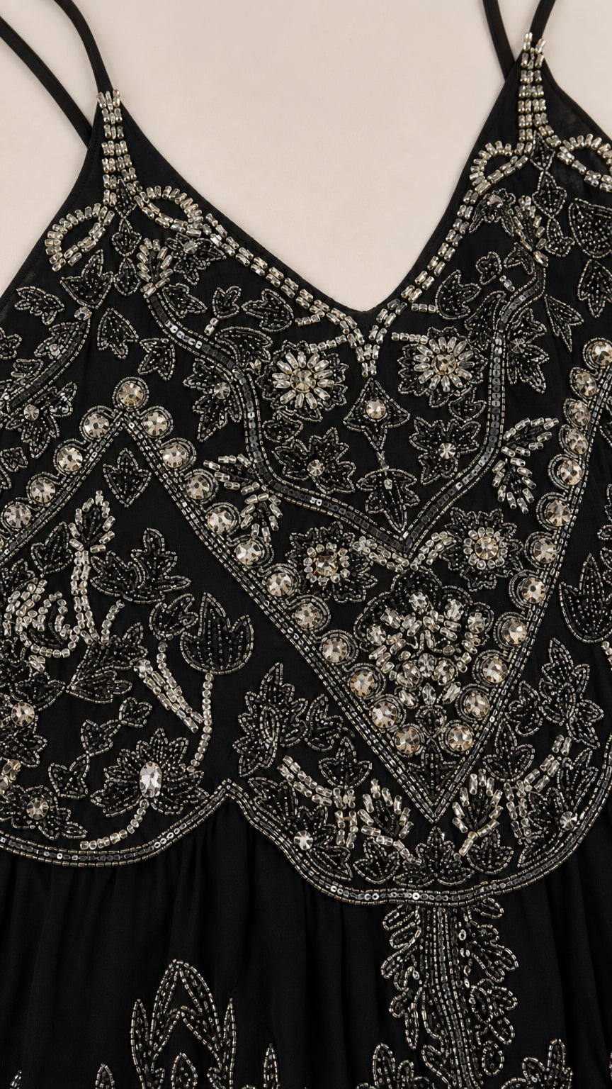 Close-up detail of intricate silver beadwork on black bodice