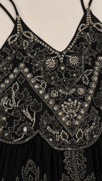 Close-up detail of intricate silver beadwork on black bodice