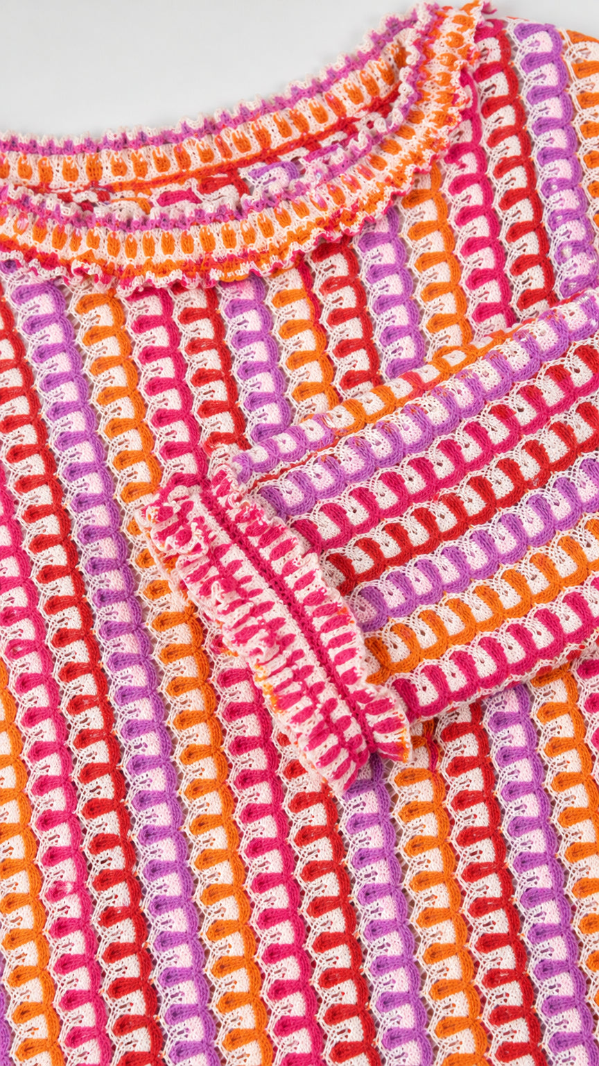 Close-up detail of crochet knit pattern and ruffled cuff