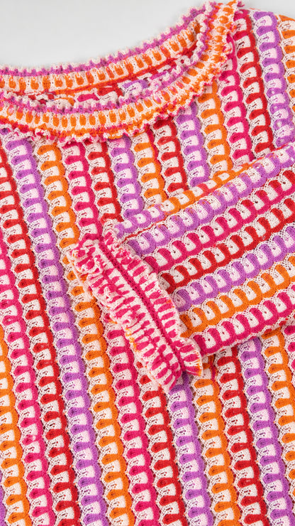 Close-up detail of crochet knit pattern and ruffled cuff