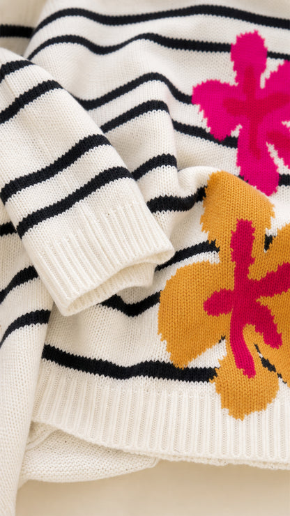 Close-up detail of soft white ribbed knit hem, horizontal stripes, and pink and mustard floral jacquard motif