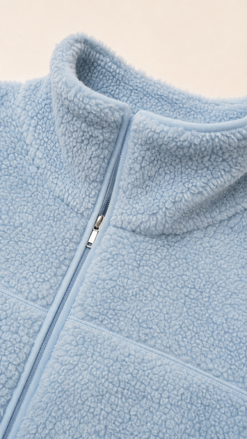 Close-up detail of Light Blue sherpa fleece texture and zipper closure