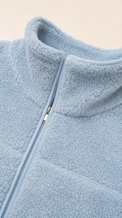 Close-up detail of Light Blue sherpa fleece texture and zipper closure