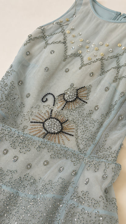 Close-up detail of intricate bead and sequin embroidery on mesh fabric