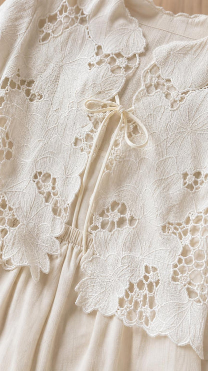 Close-up detail of beige floral lace embroidery and front tie