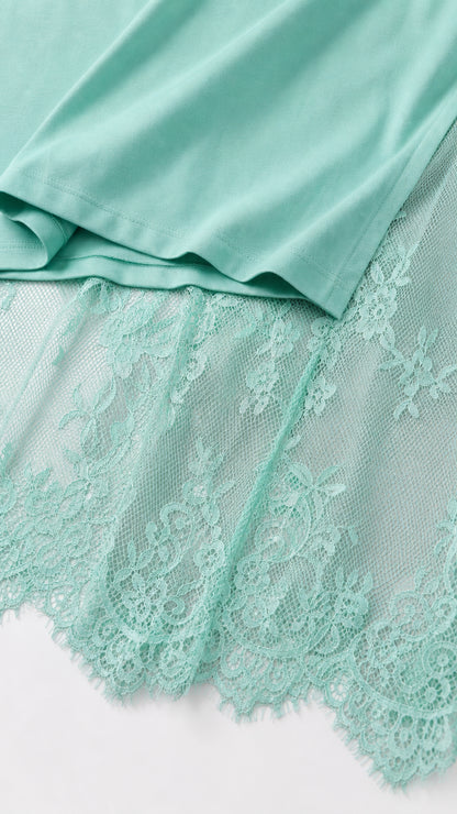 Close-up detail of mint green knit fabric hem and delicate floral eyelash lace