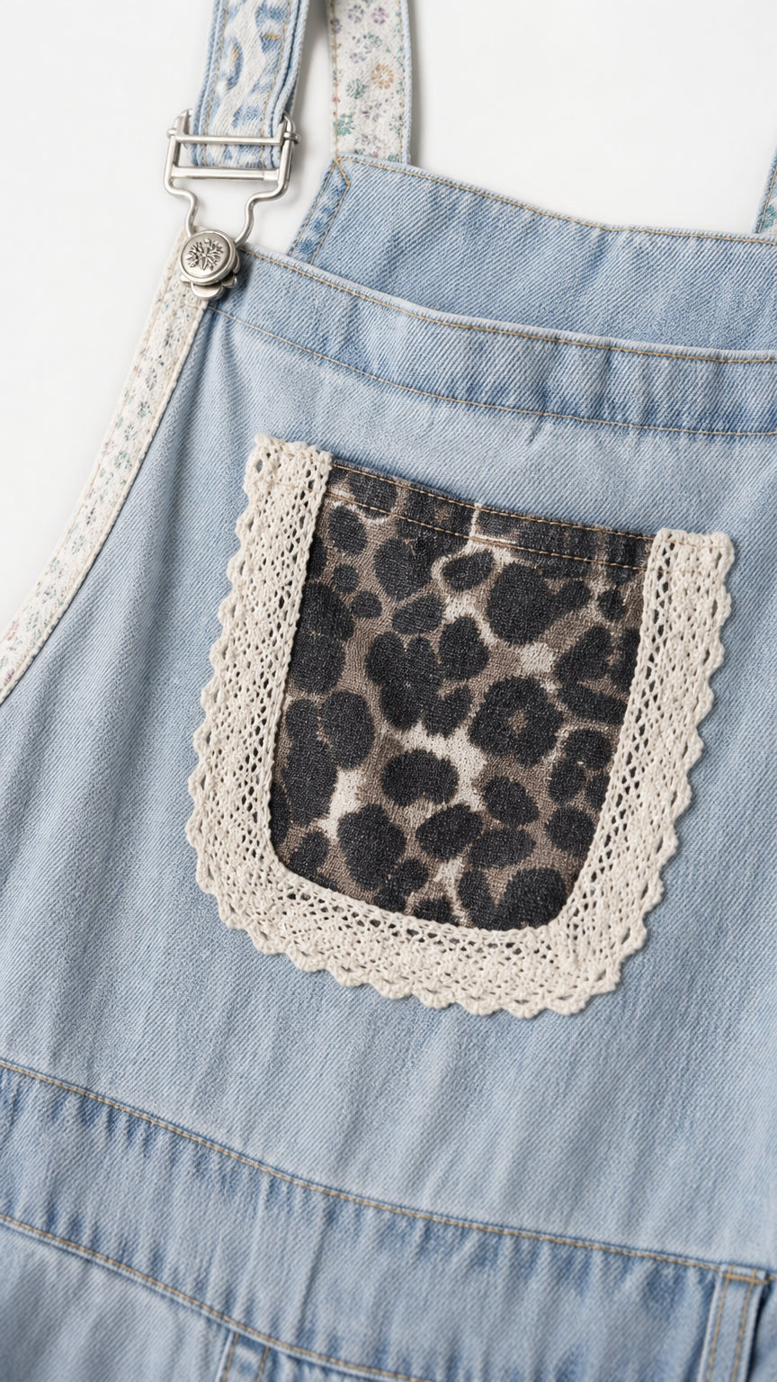 Close-up detail of front bib pocket with animal print and lace trim