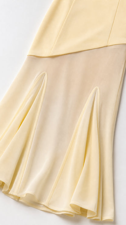 Close-up detail of sheer panel and pleated hem on dress