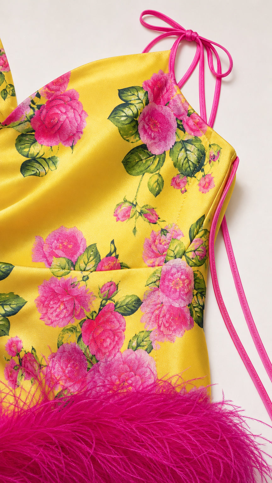 Close-up detail of fabric, floral pattern, and feather trim