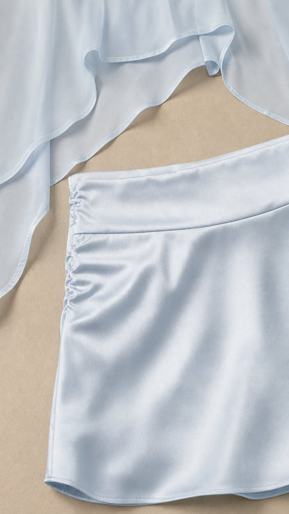 Close-up of sheer cape top fabric and ruched skirt waistband