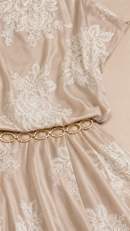 Close-up detail of floral embroidery and metallic chain belt on Champagne dress