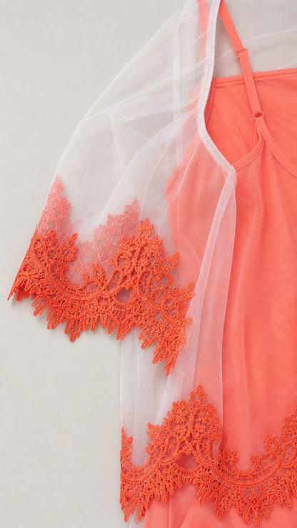 Close-up detail of sheer mesh sleeve with contrast embroidery on coral dress
