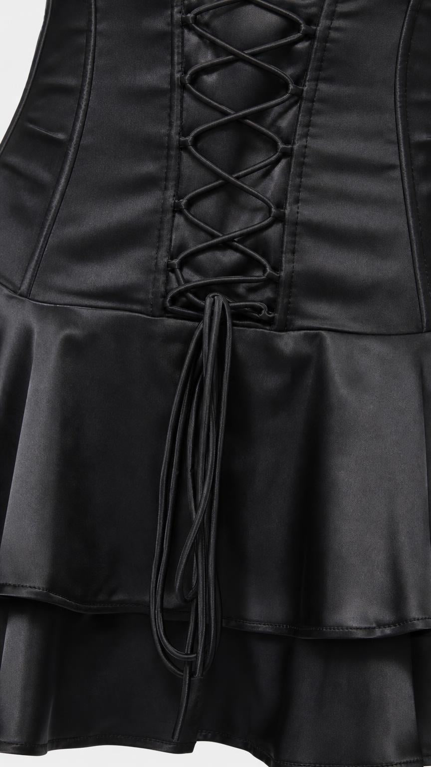 Close-up of lace-up corset detail and ruffled hem on black dress