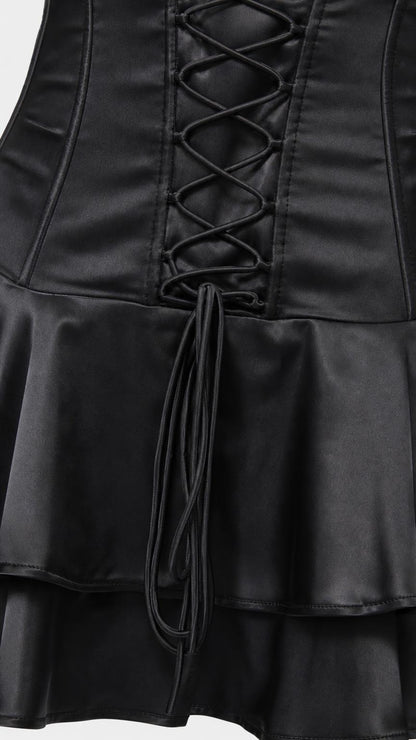 Close-up of lace-up corset detail and ruffled hem on black dress