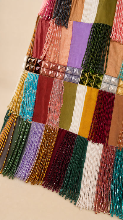 Close-up of beadwork and fringe details on patchwork dress