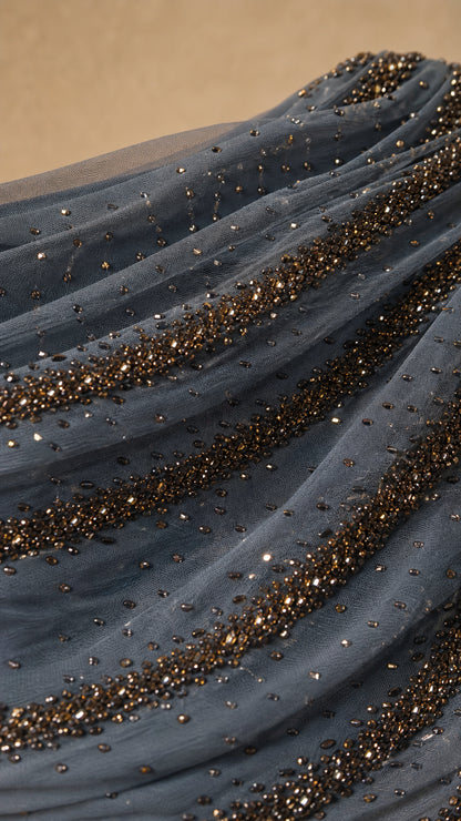 Close-up detail of sheer mesh fabric with intricate beaded lines and shimmer