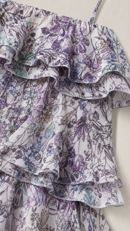 Close-up detail of layered ruffles and lavender floral print on lightweight fabric
