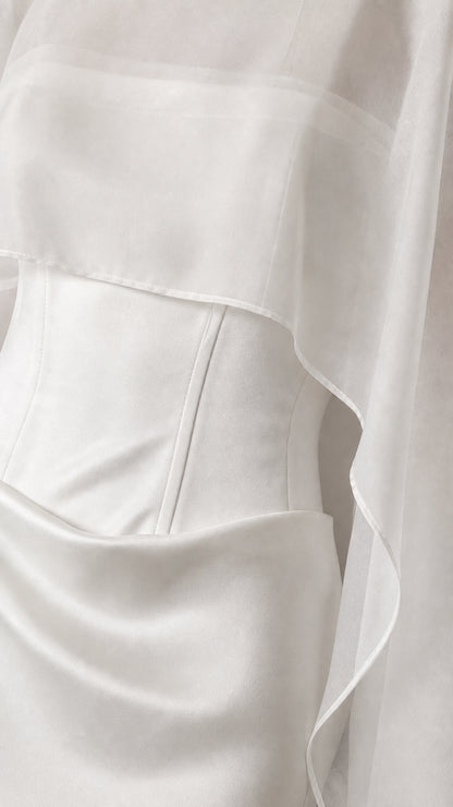 Close-up detail of the bodice and sheer overlay on white dress