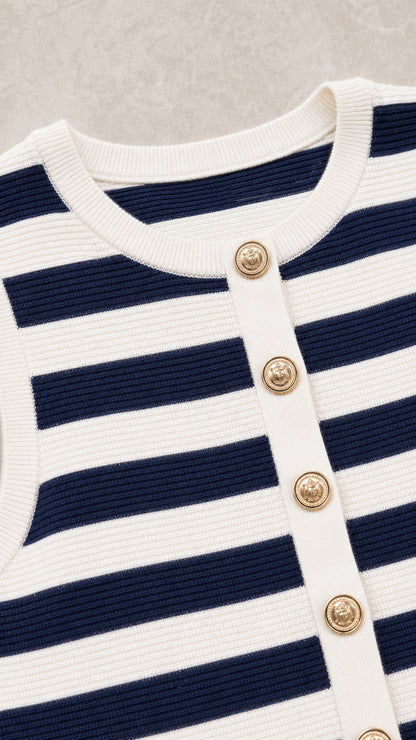 Close-up detail of neckline, gold buttons, and knit texture
