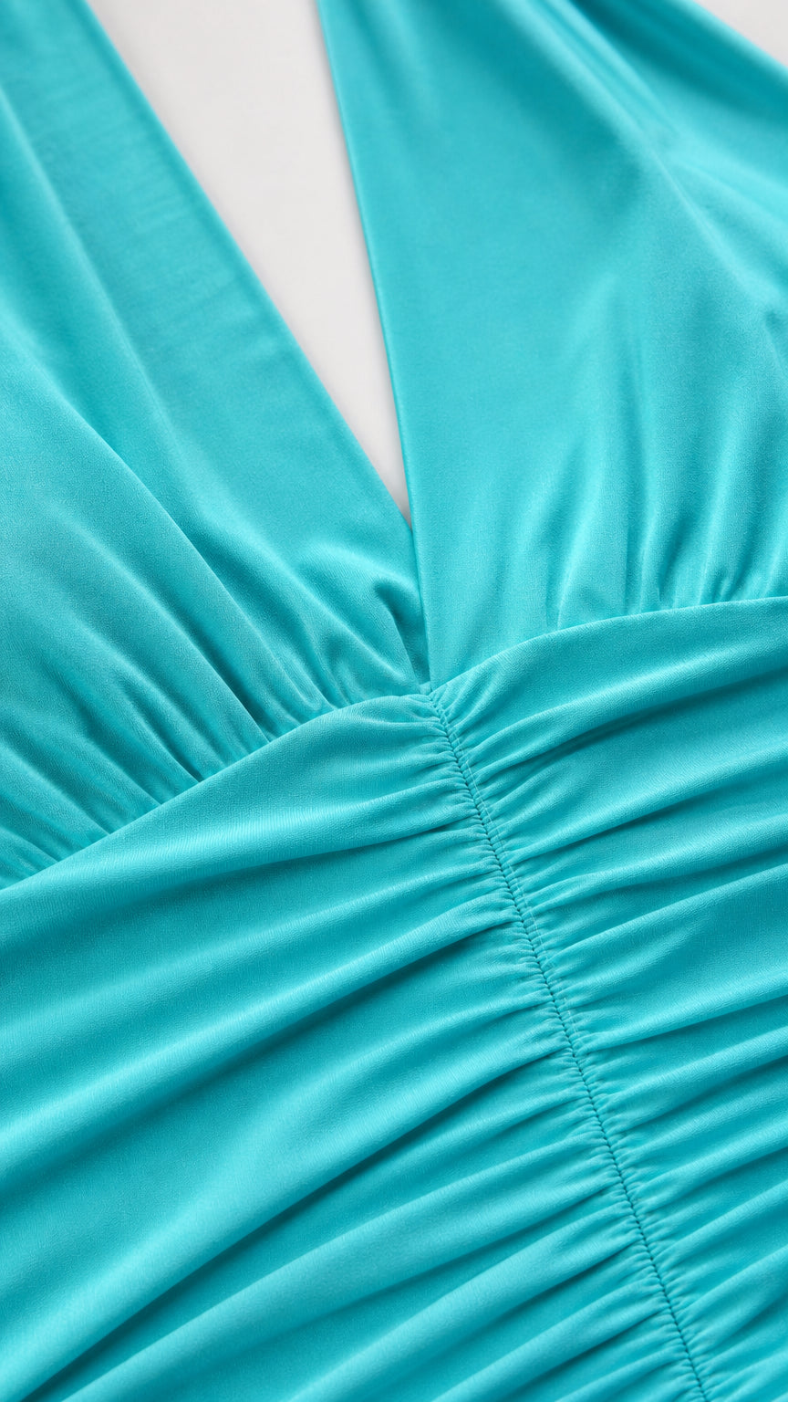 Close-up detail of front V-neckline and center ruching on turquoise dress