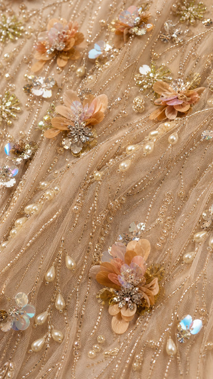 Close-up detail of 3D floral appliques, beads, and sequins on Champagne mesh fabric