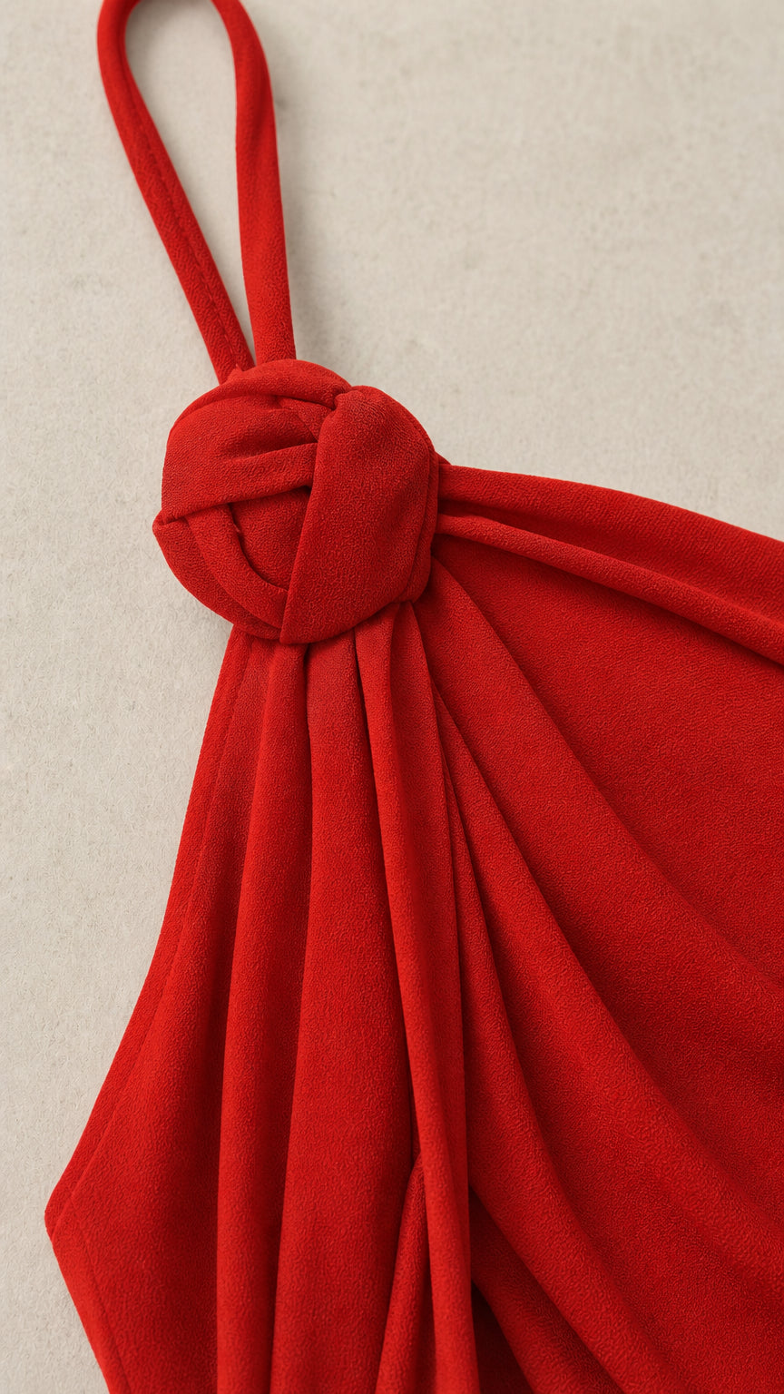 Close-up detail of the decorative shoulder knot and straps in red