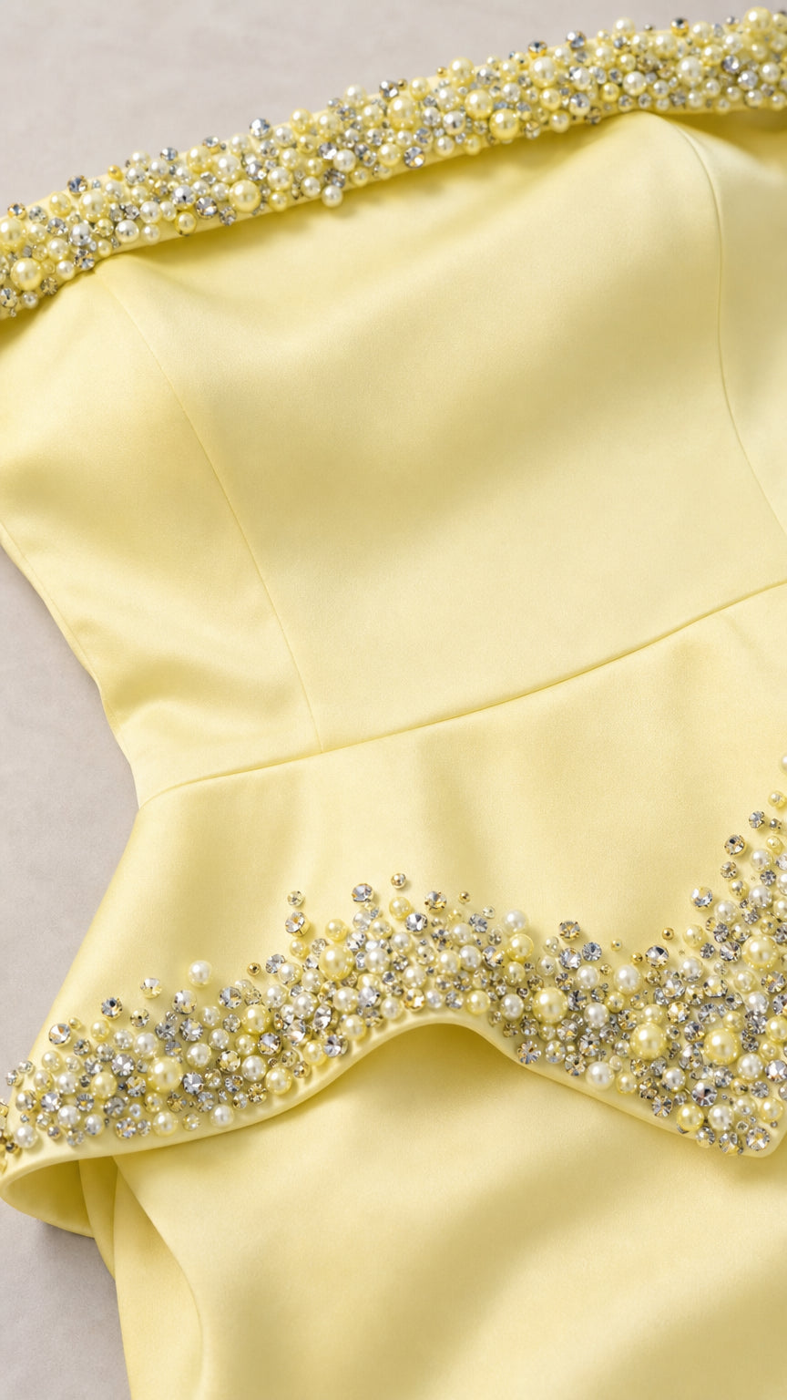 Close-up detail of pearl and crystal bead embellishment on neckline and peplum waist