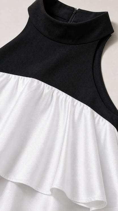 Close-up detail of black mock neck and white ruffle overlay
