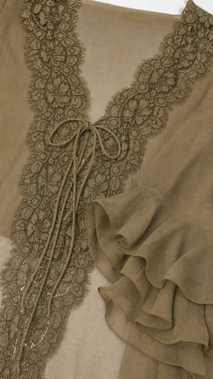 Close-up detail of crochet lace trim and tie strings on olive blouse