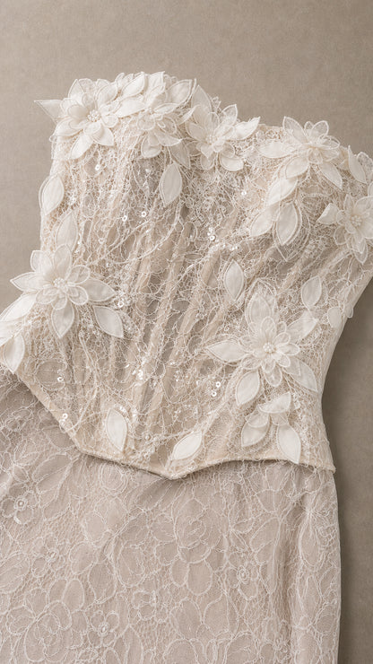 Close-up detail of 3D floral appliques and textured lace on bodice
