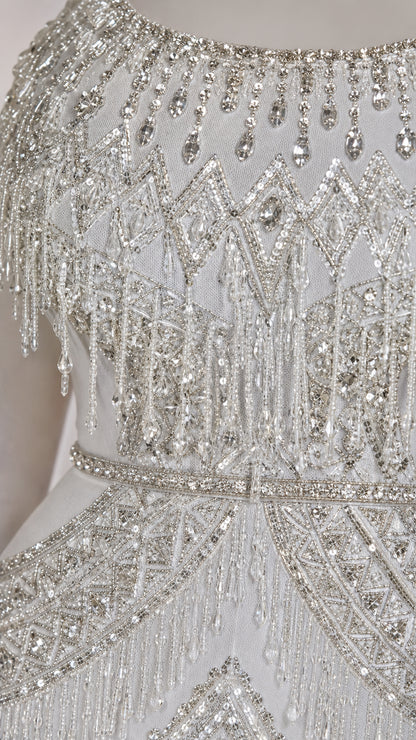 Detailed close-up of intricate crystal beadwork, sequins, and shoulder fringe