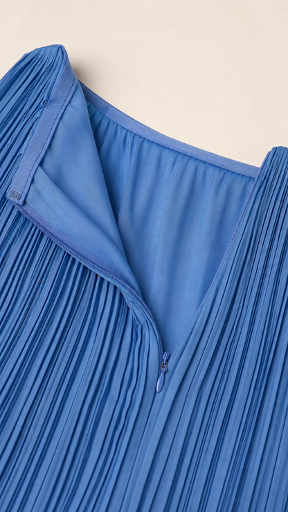 Close-up of side zipper and pleated fabric detail on blue dress