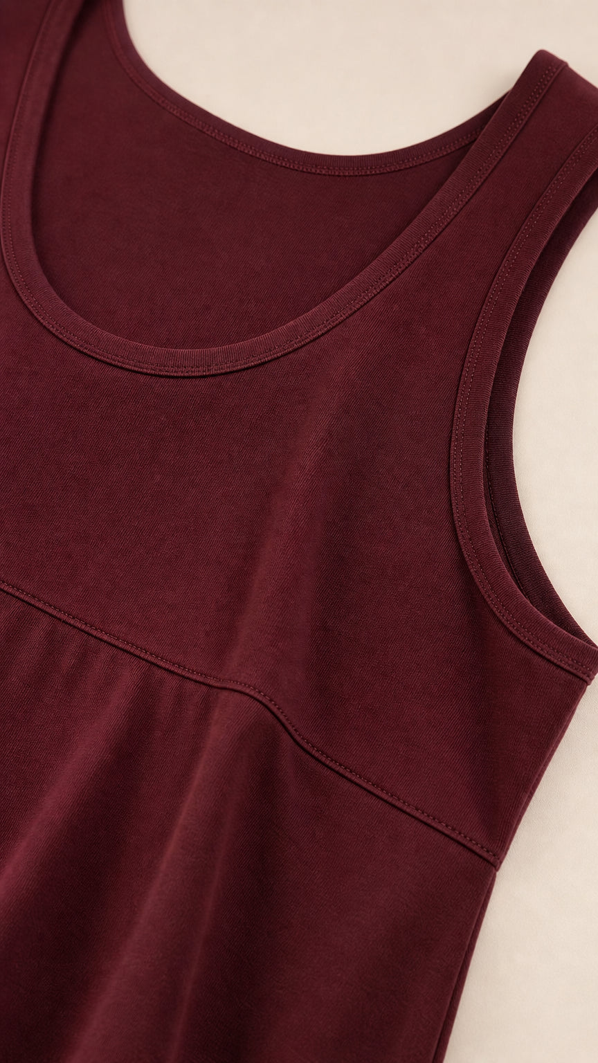 Close-up detail of burgundy scoop neckline and waist seam stitching