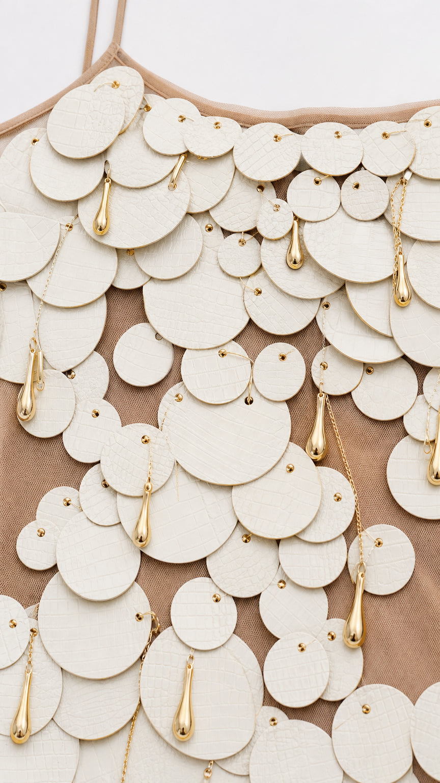 Close-up detail of textured coin appliqués and metallic charms