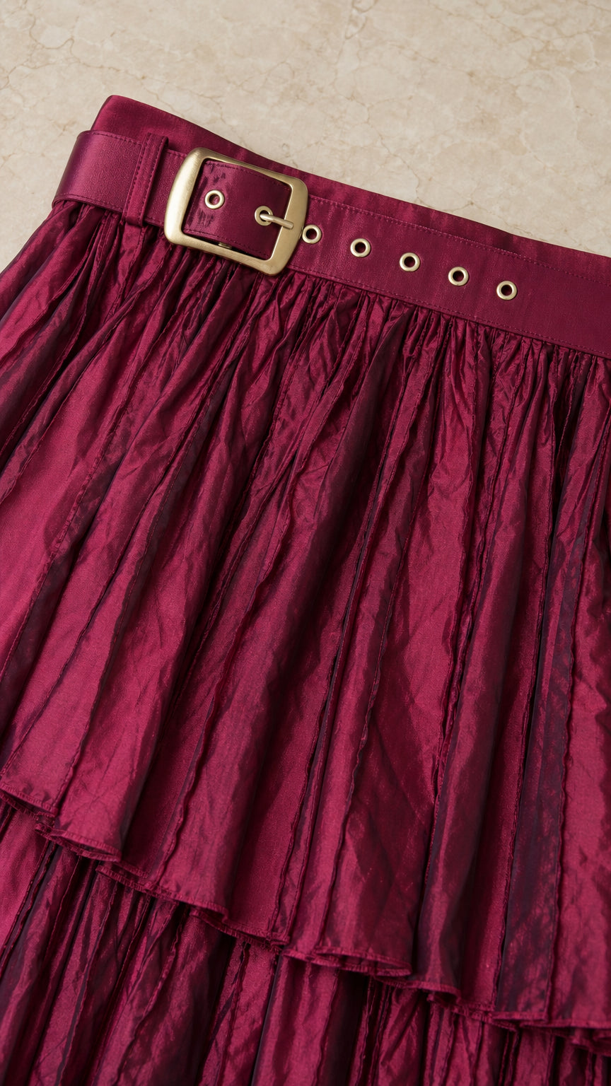 Close-up detail of bust band with metallic grommet buckle and pleated texture