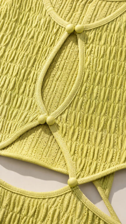 Close-up of olive green dress fabric texture and cutout button details