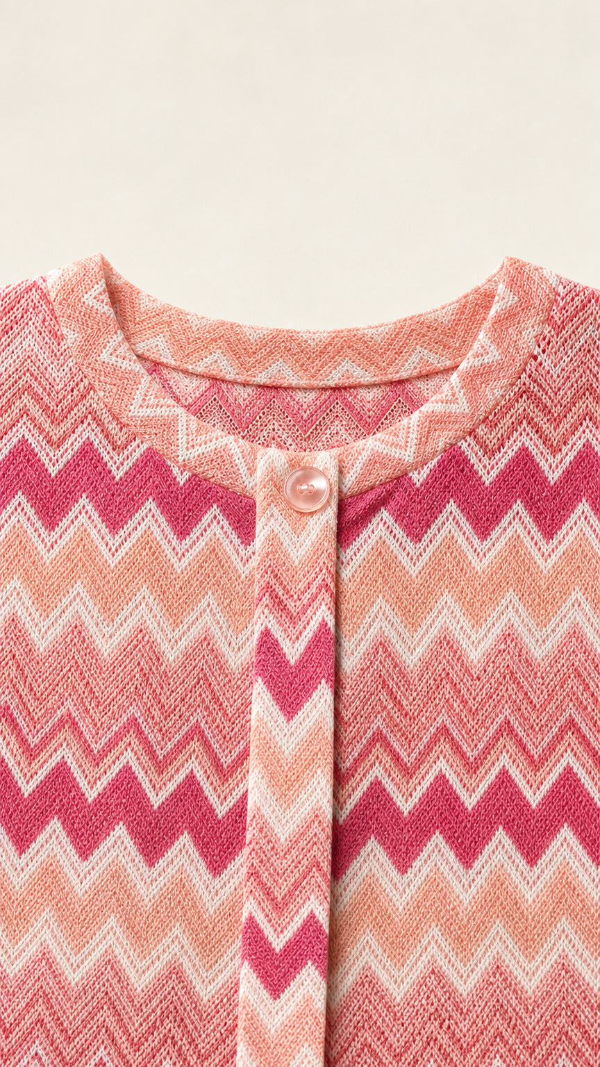 Close-up detail of pink chevron knit fabric, crew neckline, and button closure