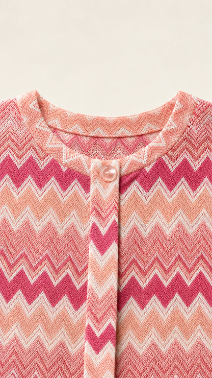 Close-up detail of pink chevron knit fabric, crew neckline, and button closure