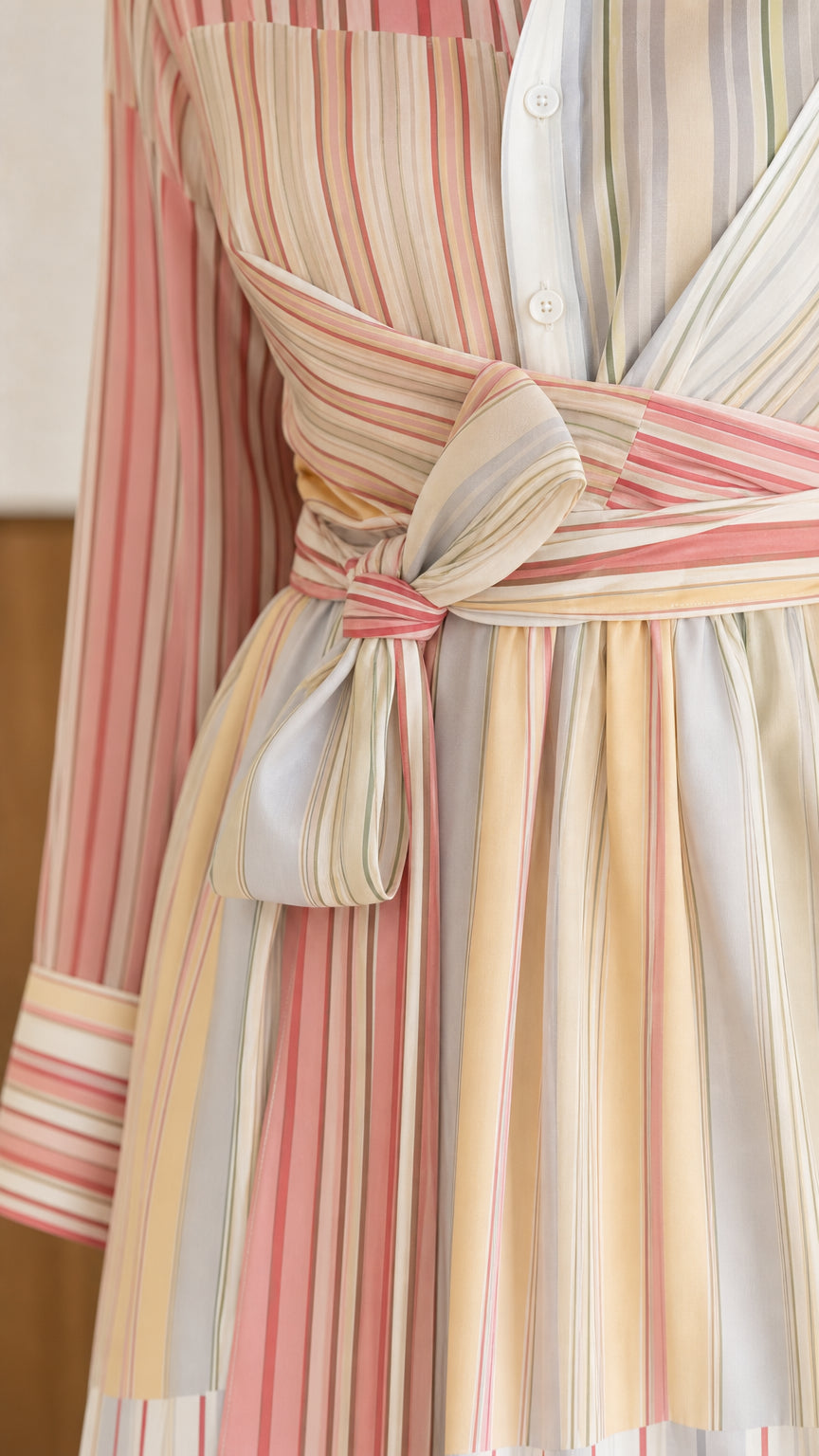 Close-up detail of crossover wrap tie waist and striped fabric pattern