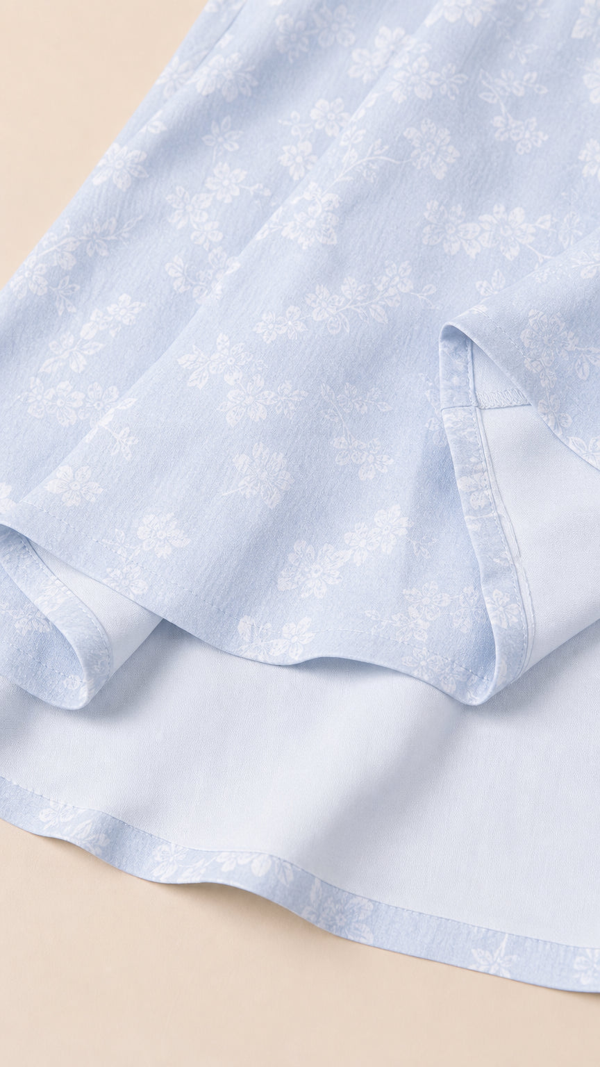 Close-up of Light Blue woven floral fabric and hemline