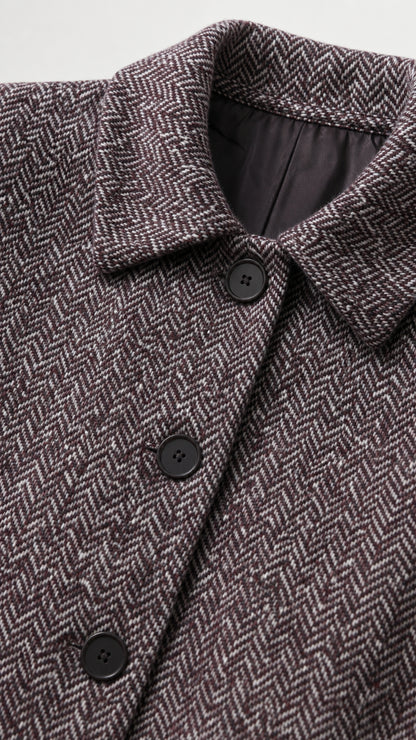 Close-up detail of point collar and dark buttons on herringbone tweed fabric