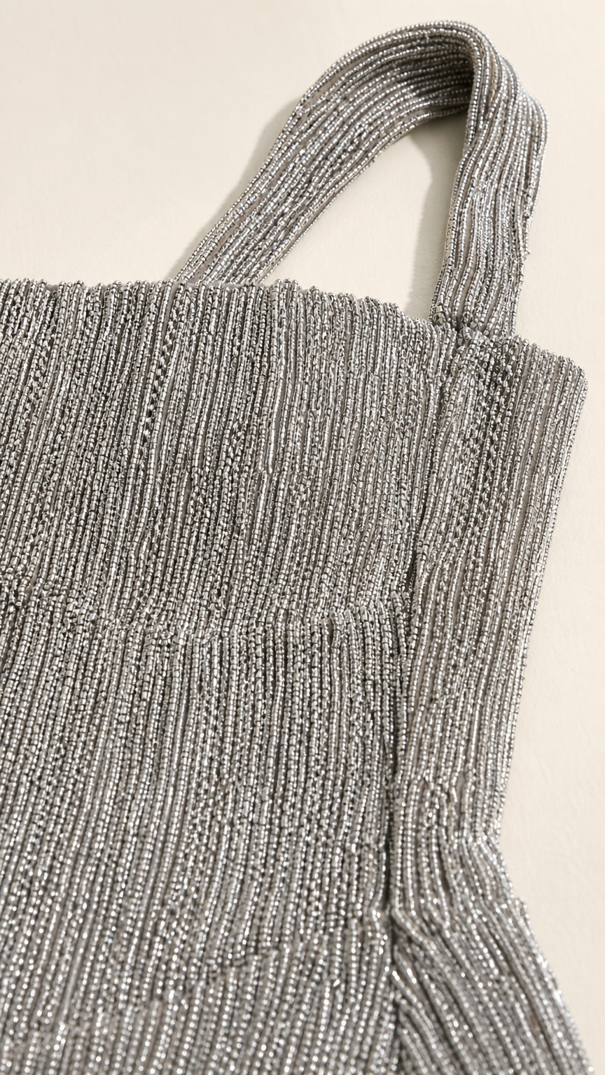 Close-up detail of textured fabric and strap on silver dress