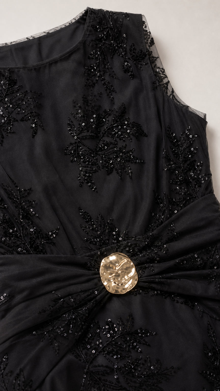 Close-up of black dress embroidery and waist buckle detail