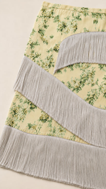 Close-up detail of yellow floral pattern and cascading fringe tiers