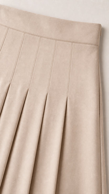 Close-up detail of beige skirt showing structured waistband and top-stitched pleats
