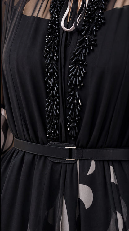 Close up of black chiffon dress neckline showing beaded fringe detail and belt