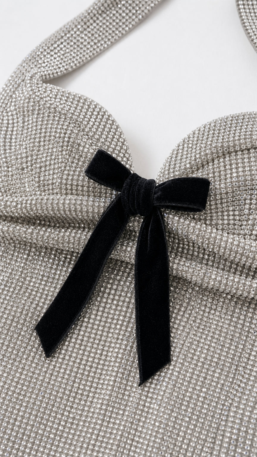 Close-up detail of black velvet bow on silver glitter bodice